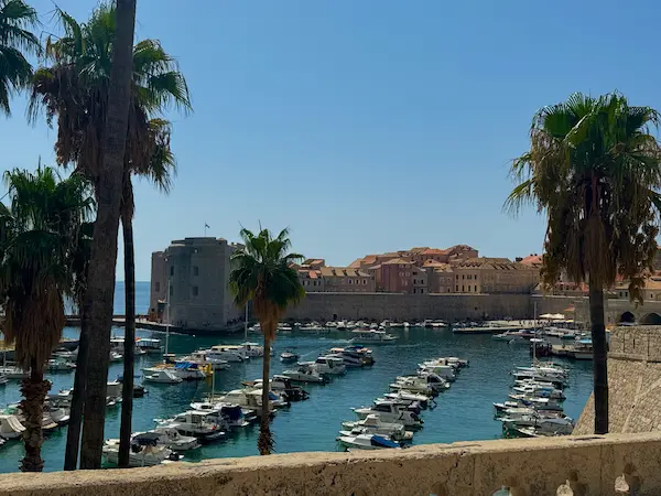 Dubrovnik Old Port Croatia - historic harbor with palm trees boats and St John fortress view